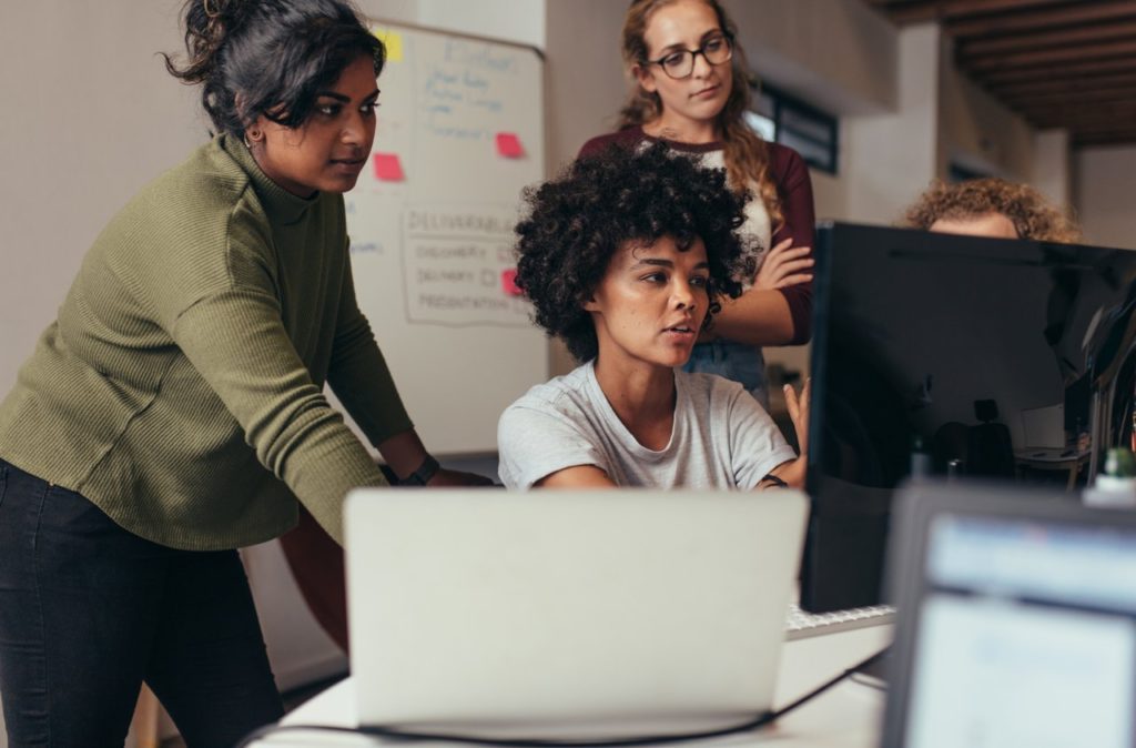 Colleagues discussing work on computer