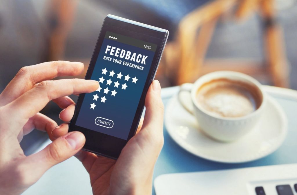 Woman rating service online and writing review on smartphone