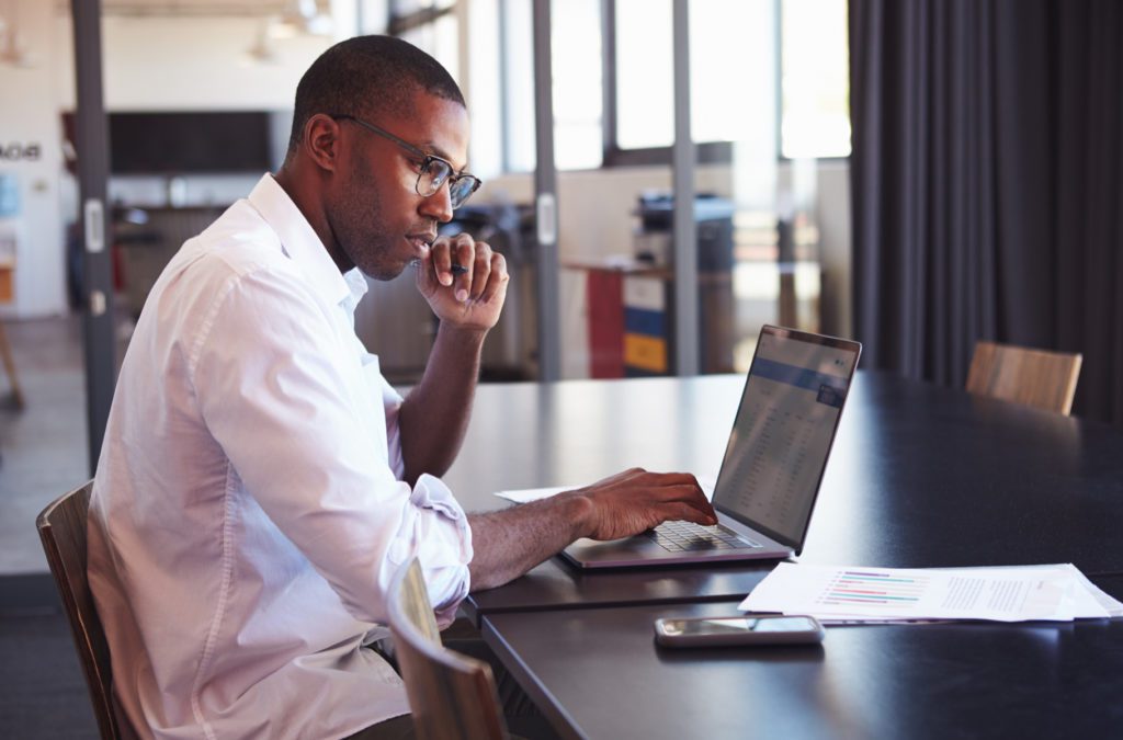 Business man reviewing business report with computer